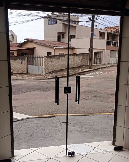 Porta de vidro temperado de duas folhas instalada em fachada comercial